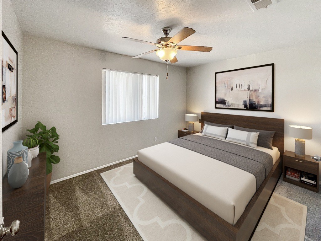 A bedroom with a large bed and a ceiling fan.
